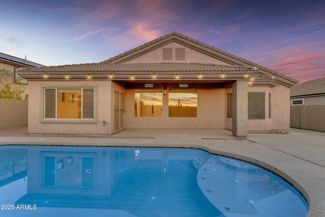 back house at dusk with a patio