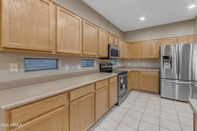 kitchen featuring stainless steel appliances, light tile patterned flooring, and light brown cabinets