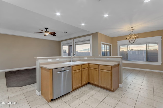 kitchen with light tile patterned flooring, stainless steel dishwasher, sink, and an island with sink