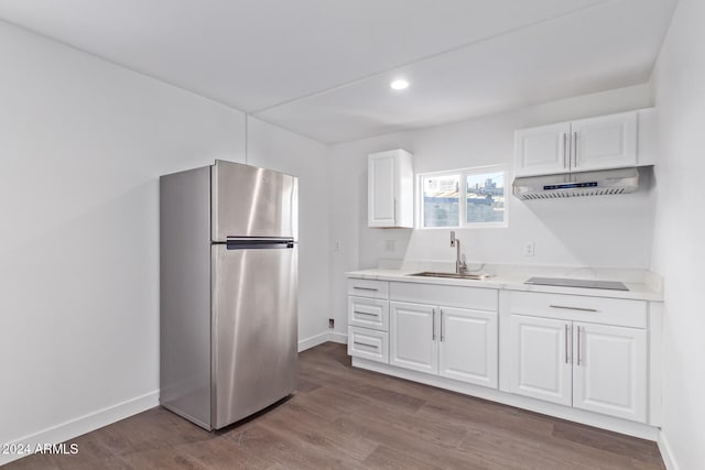 kitchen featuring stainless steel refrigerator, white cabinetry, sink, dark hardwood / wood-style floors, and black electric stovetop