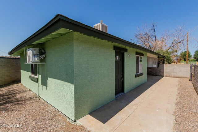 view of home's exterior with stucco siding and fence