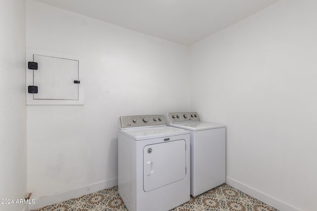 clothes washing area featuring laundry area, light floors, baseboards, and separate washer and dryer