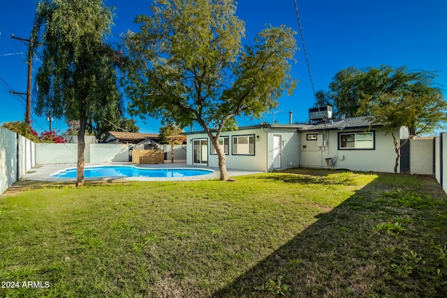 back of property featuring a yard, a fenced in pool, a fenced backyard, and a chimney