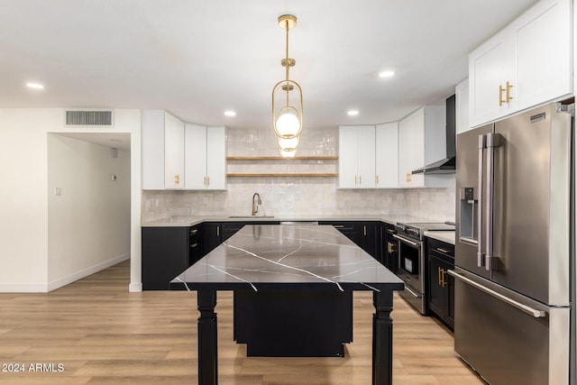 kitchen featuring visible vents, open shelves, premium appliances, wall chimney exhaust hood, and dark cabinets