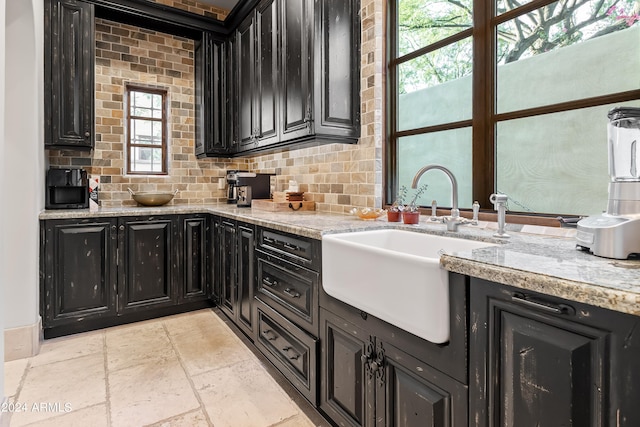 kitchen featuring light stone countertops, sink, and tasteful backsplash