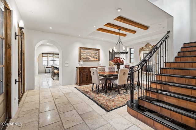 dining space with a chandelier and a raised ceiling