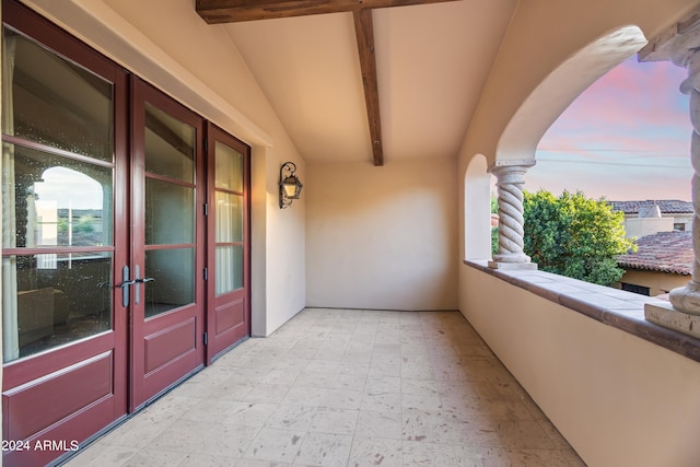 balcony at dusk featuring french doors