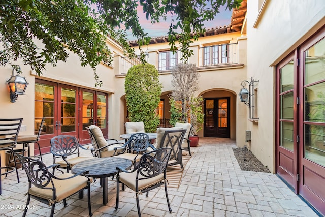 patio terrace at dusk featuring french doors