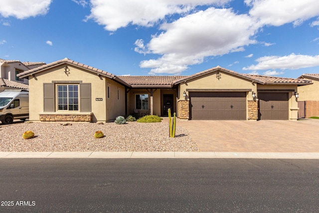 view of front of home featuring stone siding, an attached garage, and stucco siding