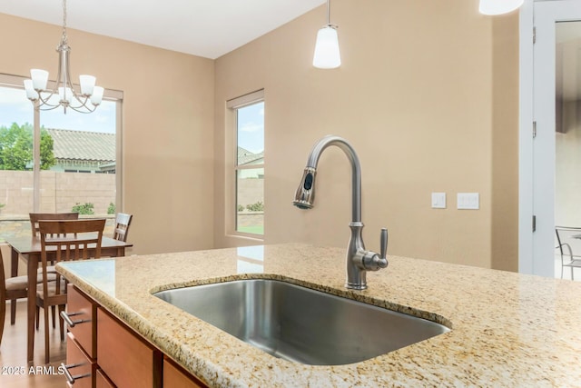 7630 E Knoll St, Mesa, AZ 85207 - kitchen with decorative light fixtures, a sink, and light stone countertops