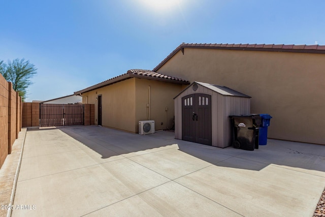 7630 E Knoll St, Mesa, AZ 85207 - view of side of property featuring stucco siding, a storage unit, a gate, fence, and an outdoor structure