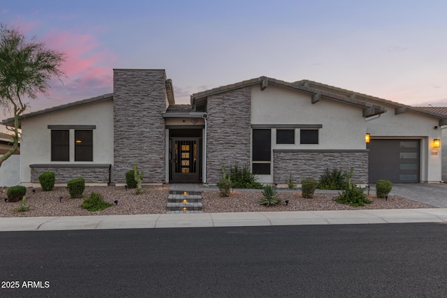 5218 N Tiller Dr, Litchfield Park, AZ 85340 - view of front of property featuring stucco siding, stone siding, an attached garage, driveway, and a chimney