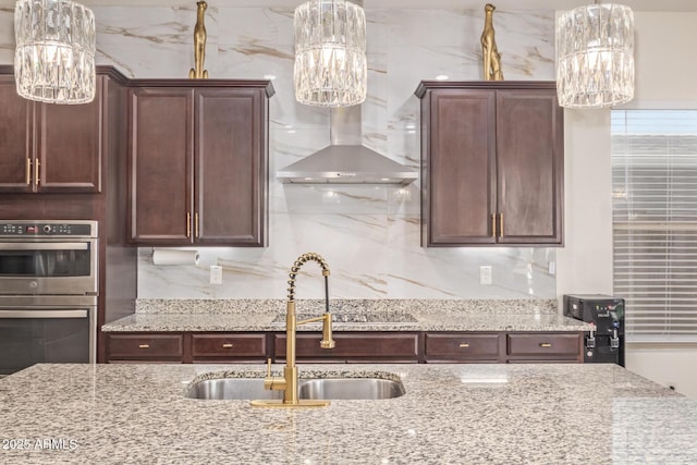 5218 N Tiller Dr, Litchfield Park, AZ 85340 - kitchen with double oven, a sink, wall chimney exhaust hood, and a chandelier