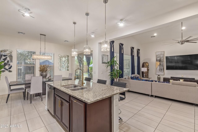 5218 N Tiller Dr, Litchfield Park, AZ 85340 - kitchen with a sink, light tile patterned floors, dishwasher, open floor plan, and light stone countertops