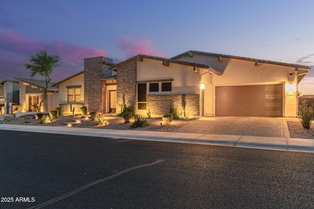 5218 N Tiller Dr, Litchfield Park, AZ 85340 - view of front of property featuring stone siding, driveway, a garage, and stucco siding