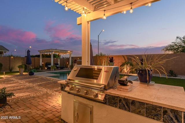 5218 N Tiller Dr, Litchfield Park, AZ 85340 - patio terrace at dusk featuring a pergola, a fenced backyard, and a patio area