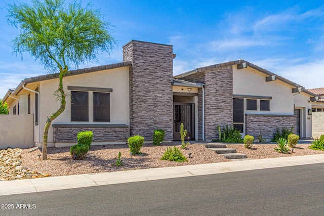 5218 N Tiller Dr, Litchfield Park, AZ 85340 - view of front of house with stone siding, stucco siding, and a garage