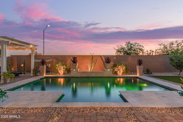 5218 N Tiller Dr, Litchfield Park, AZ 85340 - pool at dusk with a patio area and a fenced backyard