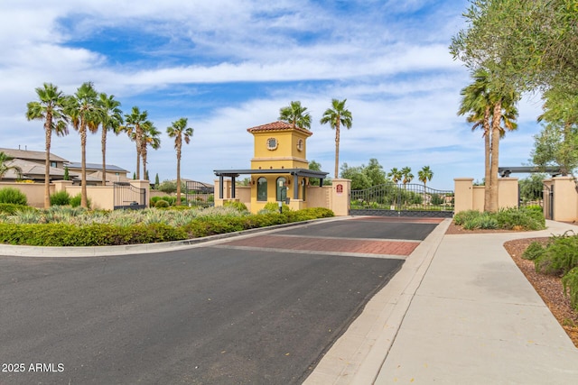 5218 N Tiller Dr, Litchfield Park, AZ 85340 - view of asphalt street featuring a gate, curbs, sidewalks, and a gated entry
