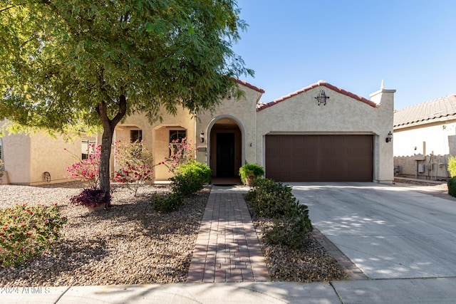 mediterranean / spanish home with a garage