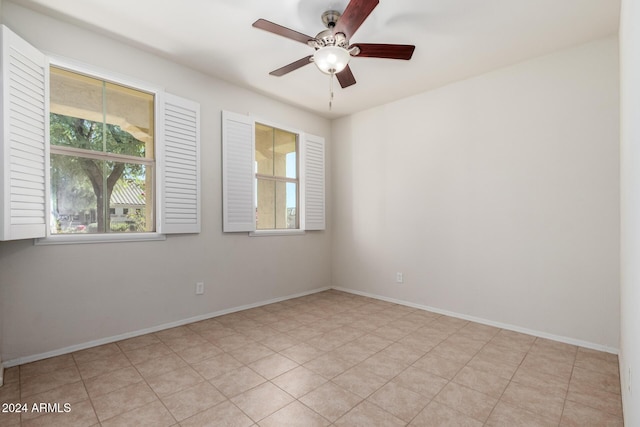 empty room with ceiling fan and light tile patterned floors