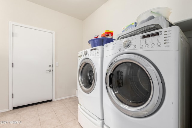 laundry room featuring light tile patterned floors and washer and clothes dryer