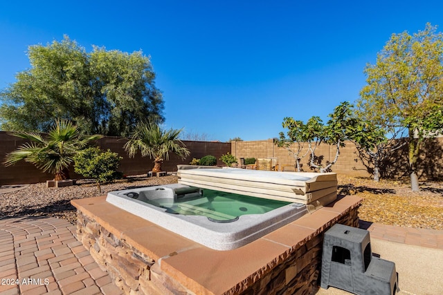 view of swimming pool with a hot tub