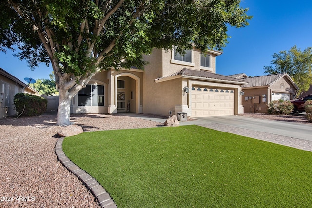 mediterranean / spanish-style house with a garage and a front yard