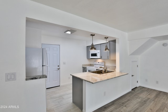 kitchen with sink, hanging light fixtures, light hardwood / wood-style flooring, kitchen peninsula, and white appliances