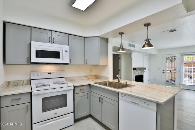 kitchen with gray cabinets, sink, white appliances, and kitchen peninsula