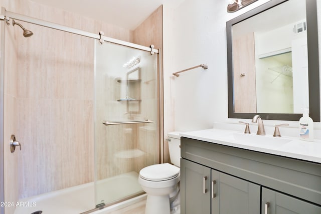 bathroom featuring vanity, toilet, and walk in shower