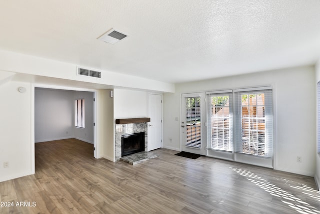 unfurnished living room featuring wood-type flooring and a fireplace