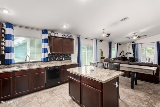 kitchen featuring a healthy amount of sunlight, sink, black dishwasher, and a kitchen island