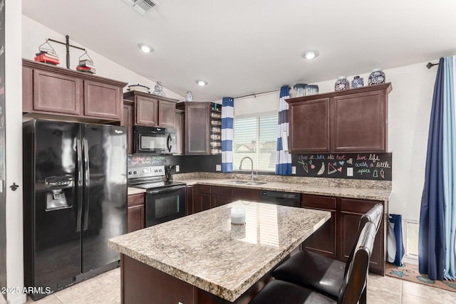 kitchen featuring lofted ceiling, sink, a center island, dark brown cabinetry, and black appliances