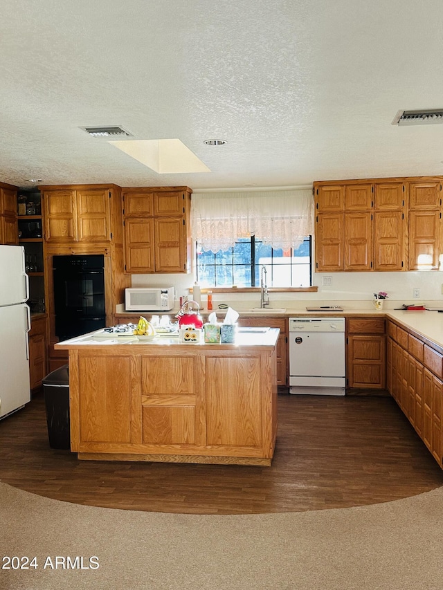 kitchen with dark hardwood / wood-style floors, sink, white appliances, and a textured ceiling