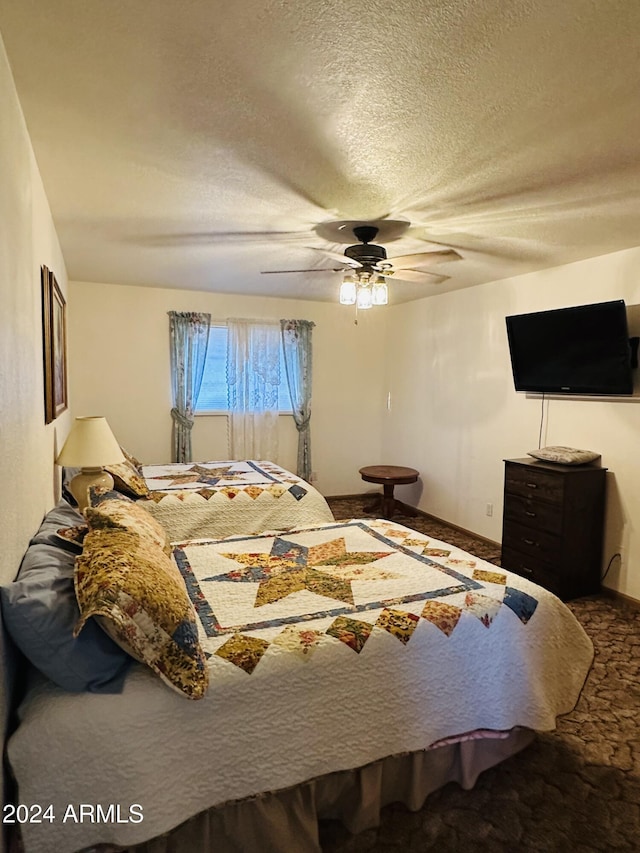 carpeted bedroom featuring a textured ceiling and ceiling fan