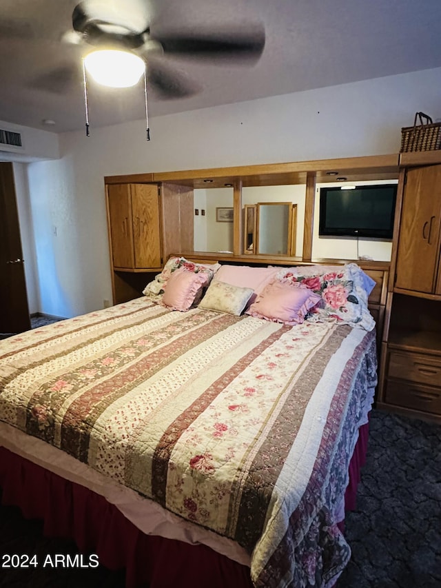 bedroom with dark colored carpet and ceiling fan