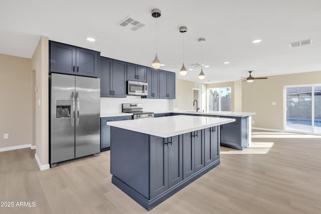 7607 N 42nd Ln, Phoenix, AZ 85051 - kitchen with stainless steel appliances, a peninsula, light wood finished floors, light countertops, and a ceiling fan