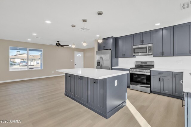 7607 N 42nd Ln, Phoenix, AZ 85051 - kitchen featuring stainless steel appliances, light wood-type flooring, ceiling fan, light countertops, and a kitchen island