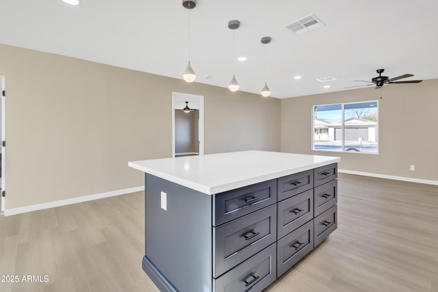 7607 N 42nd Ln, Phoenix, AZ 85051 - kitchen with light wood-style flooring, gray cabinetry, light countertops, a center island, and recessed lighting