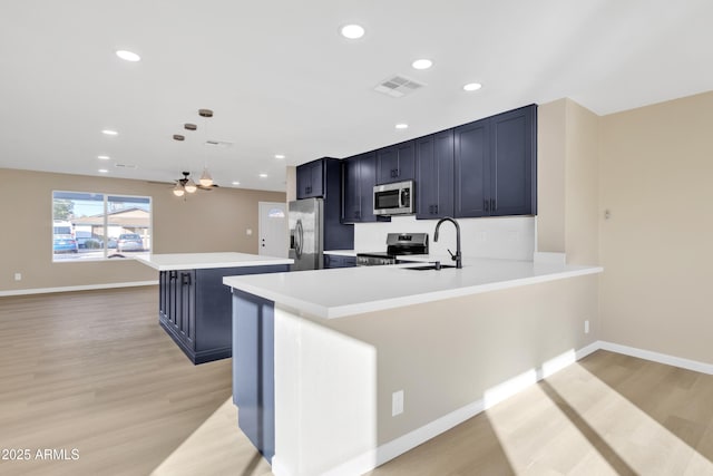 7607 N 42nd Ln, Phoenix, AZ 85051 - kitchen featuring appliances with stainless steel finishes, a sink, light countertops, light wood-type flooring, and recessed lighting
