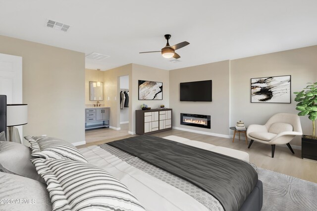 7607 N 42nd Ln, Phoenix, AZ 85051 - bedroom with light wood finished floors, baseboards, a glass covered fireplace, and a sink