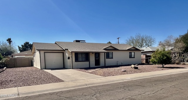 ranch-style house with brick siding, a shingled roof, concrete driveway, an attached garage, and fence