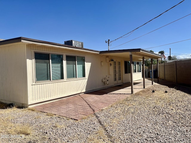 rear view of house featuring central AC unit, a patio area, and fence