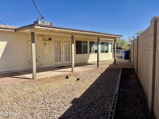 back of property with french doors, a patio area, and fence