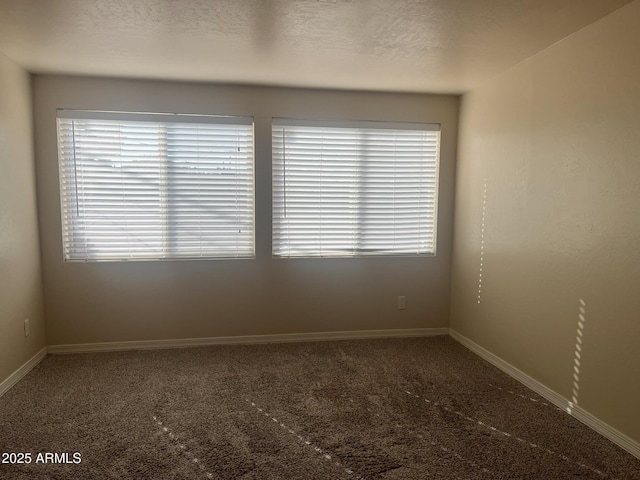 unfurnished room featuring carpet floors, plenty of natural light, and baseboards