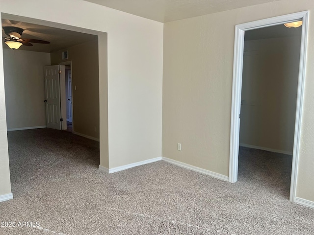 spare room featuring a ceiling fan, carpet flooring, visible vents, and baseboards