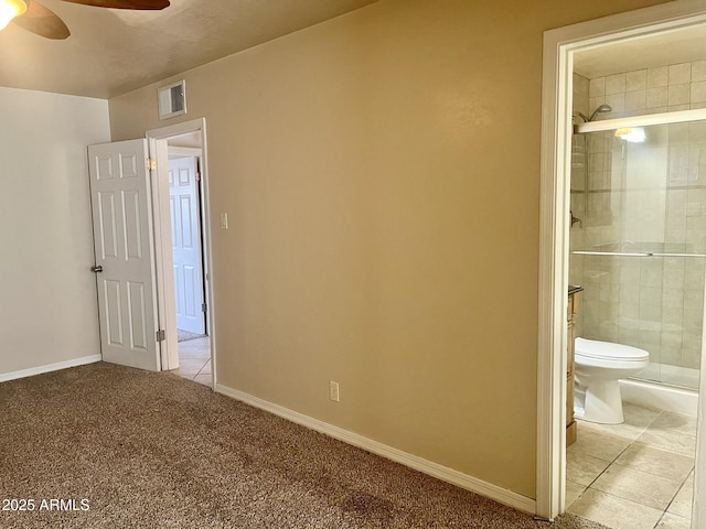 unfurnished bedroom featuring carpet floors, visible vents, connected bathroom, baseboards, and tile patterned floors