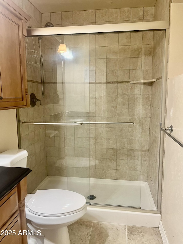 bathroom with a stall shower, vanity, and toilet