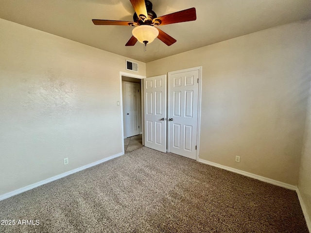 unfurnished bedroom with ceiling fan, carpet flooring, visible vents, and baseboards